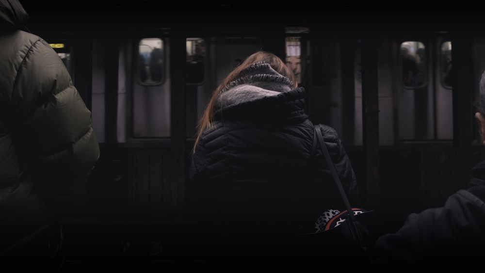 person in black coat standing in front of white panel door