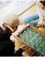 man and woman playing foosball table