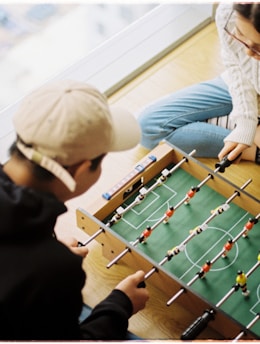 man and woman playing foosball table