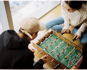 man and woman playing foosball table
