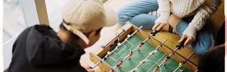 man and woman playing foosball table