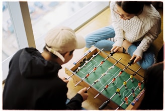 man and woman playing foosball table