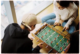 man and woman playing foosball table