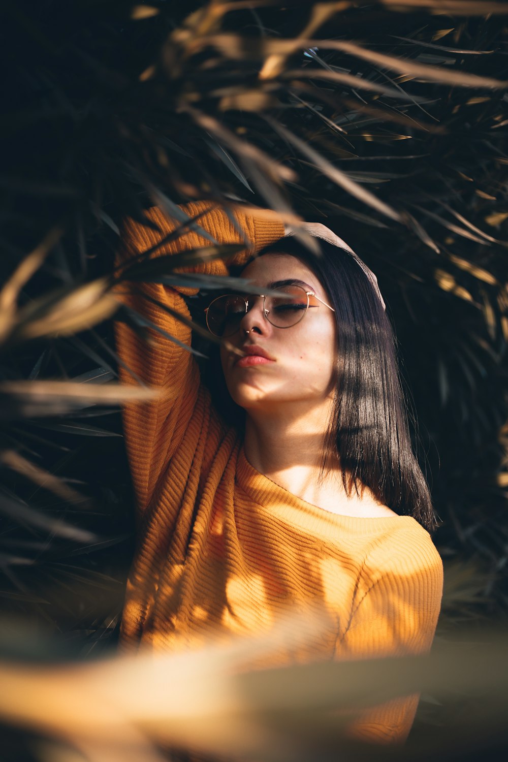 mujer sosteniendo su cabeza blanca de pie en medio de las plantas