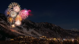 fireworks display from snow capped mountain during nighttime