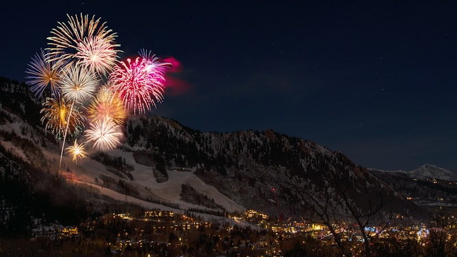 fireworks display from snow capped mountain during nighttime