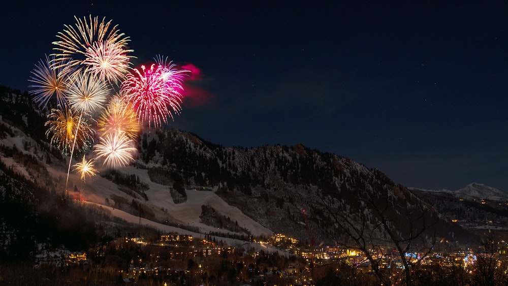 fireworks display from snow capped mountain during nighttime