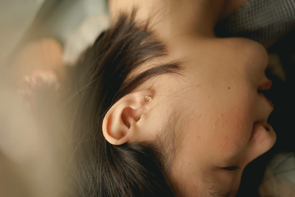 Close-up view of person's face and neck with dark hair framing their features