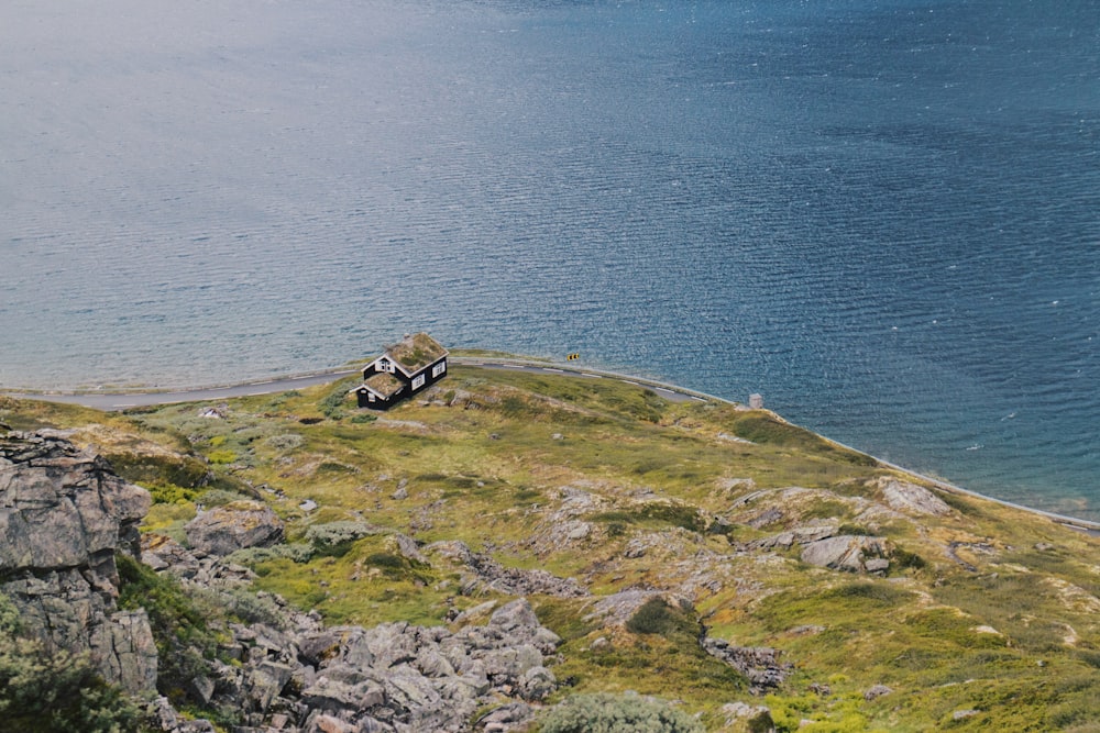 photo of house on cliff near body of water