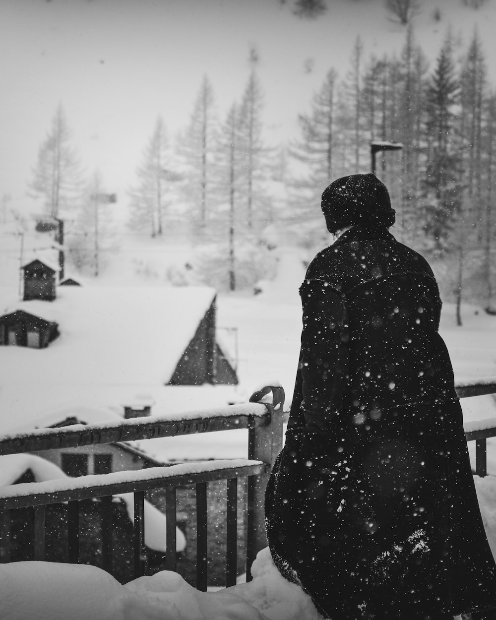 Persona de pie cerca de casas cubiertas de nieve