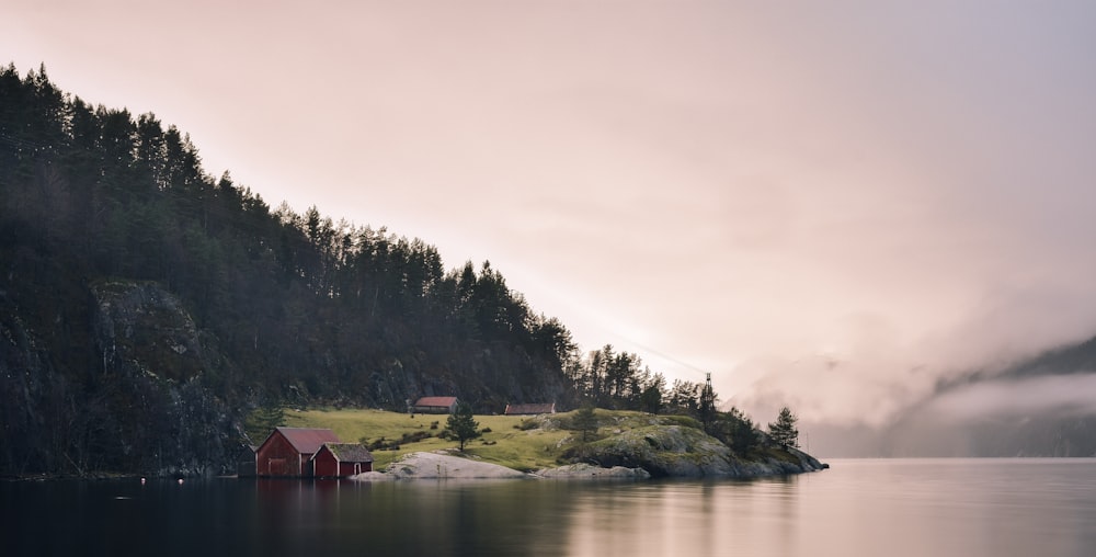 green mountain beside sea under gray sky