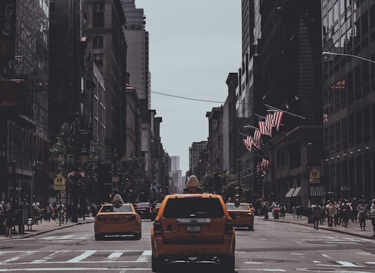 orange vehicle passing on road in Manhattan United States