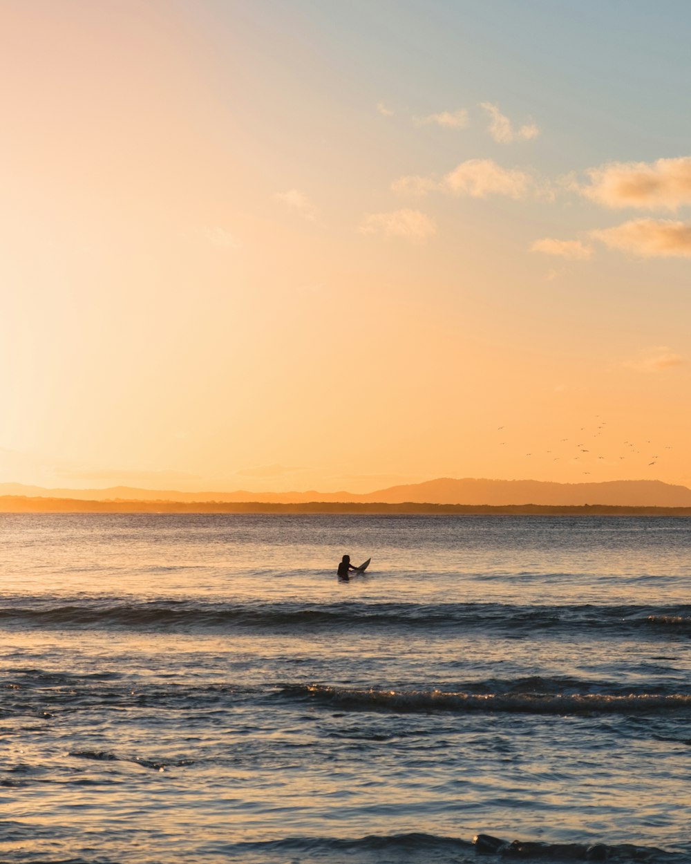 photo of person holding surfboard at the sea