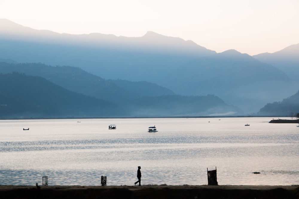 white sailboat in the middle of body of water