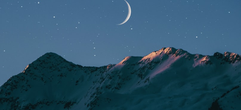 crescent moon above mountain