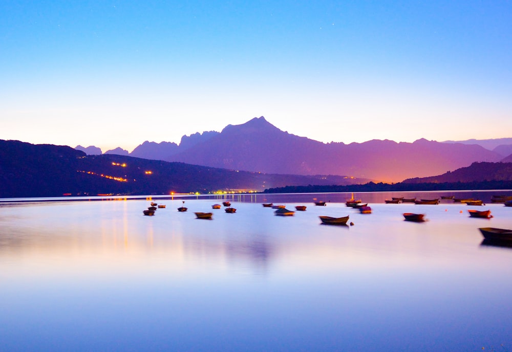 boats in body of water overlooking mountain