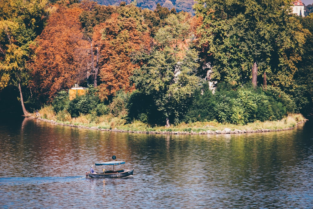 boat on body of water near trees during daytime