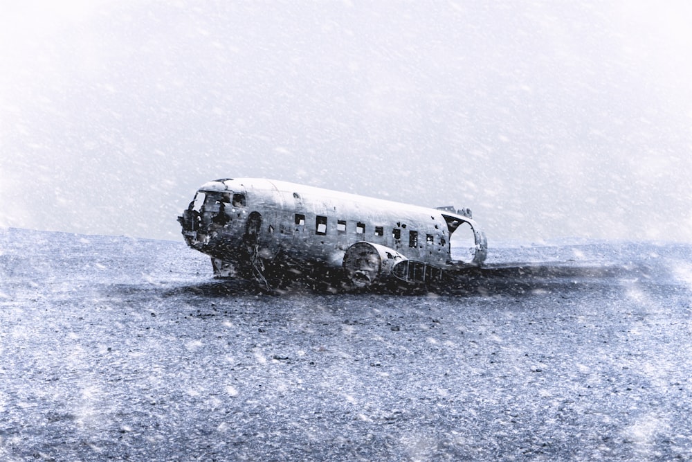 avión estrellado en arena fotografía en escala de grises