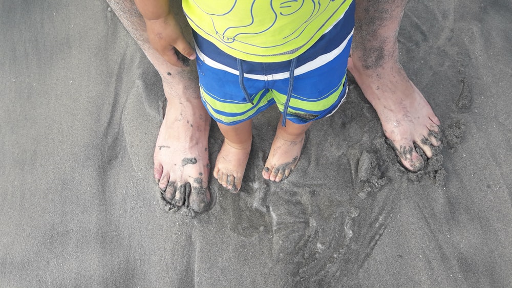 Ein kleines Kind, das im Sand an einem Strand steht