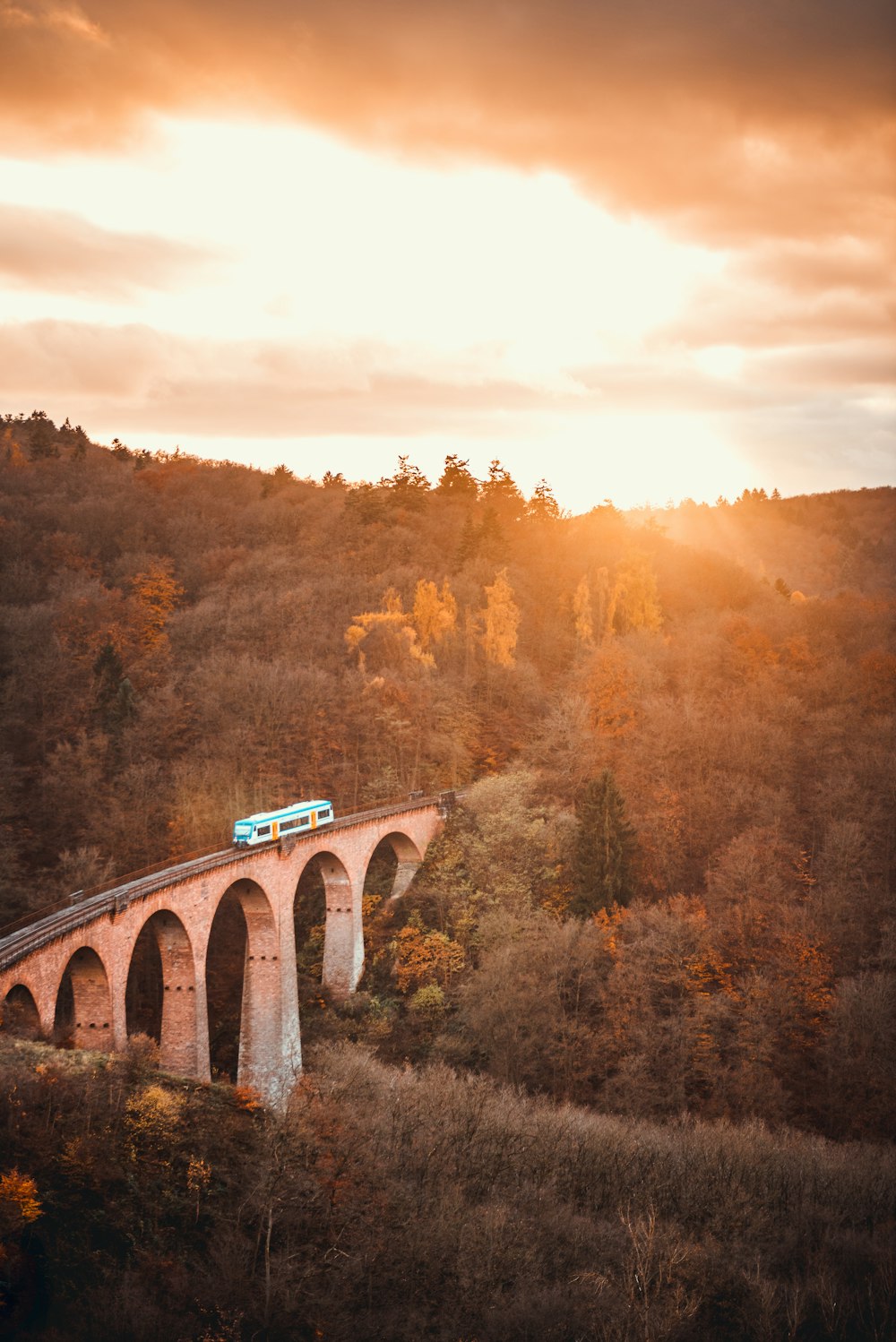 Fotografía de vista aérea del tren en el puente durante la puesta del sol