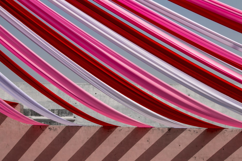 a red, white, and pink canopy with a building in the background