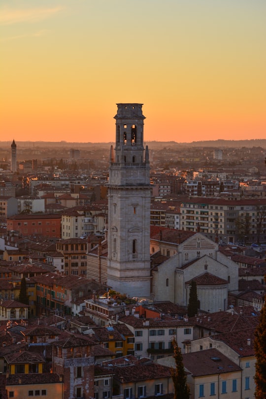 white concrete tower in a city during golden hour in Verona Italy