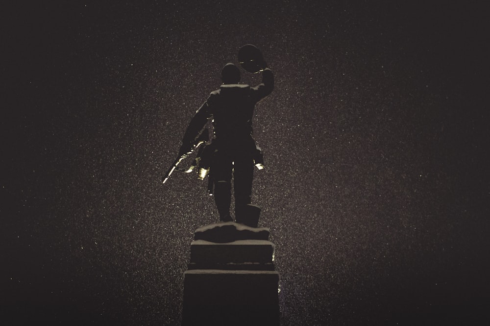 silhouette of statue against black background