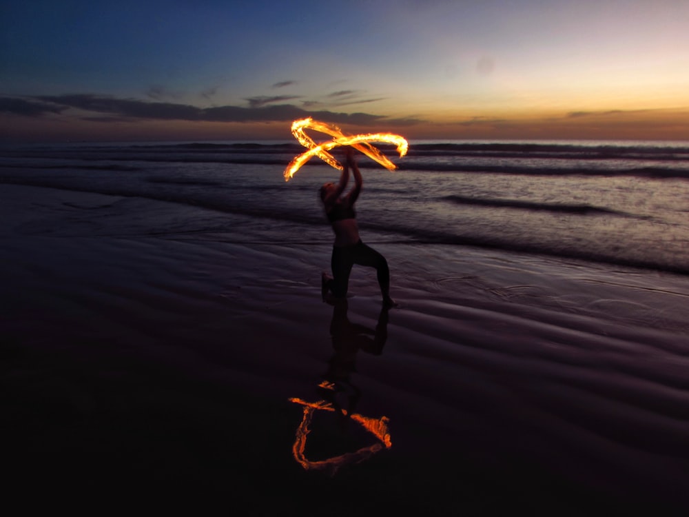 person doing fire dancing on seashore