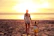 woman and child facing towards sunset