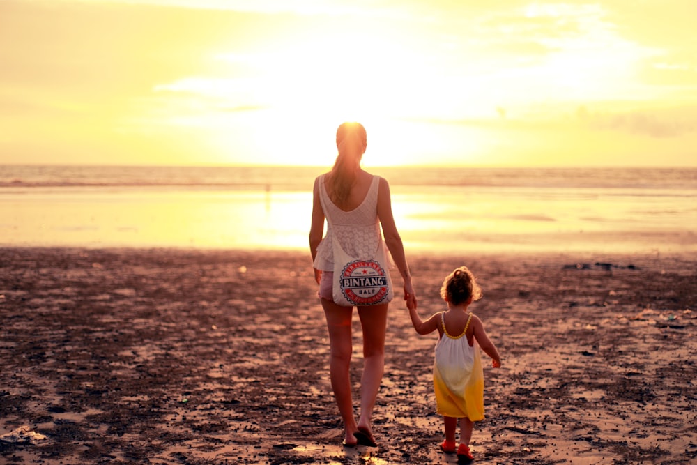 Frau und Kind blicken dem Sonnenuntergang entgegen