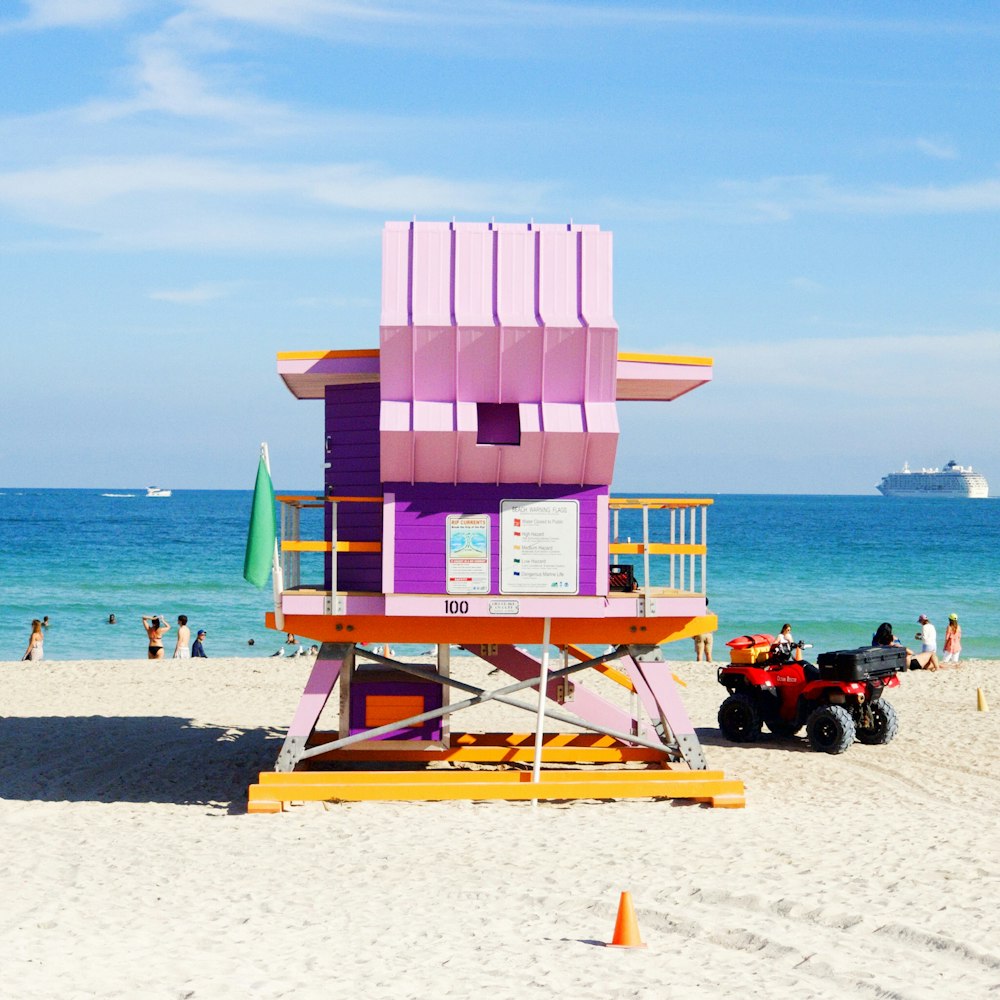 pink and multicolored lifeguard house near ocean at daytime