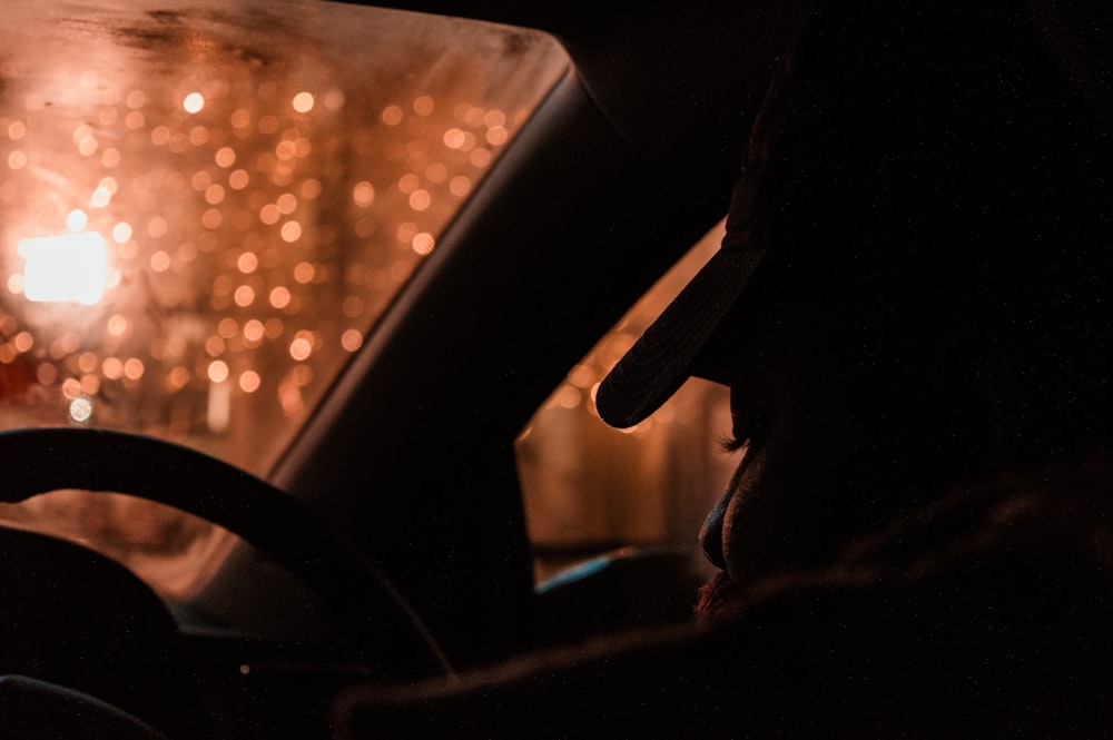 Silhouette einer Person, die nachts ein Fahrzeug fährt
