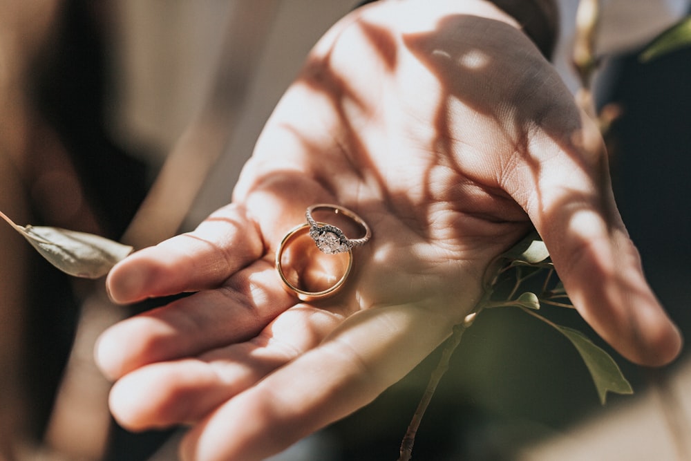 personne tenant l’ensemble de bague de mariée