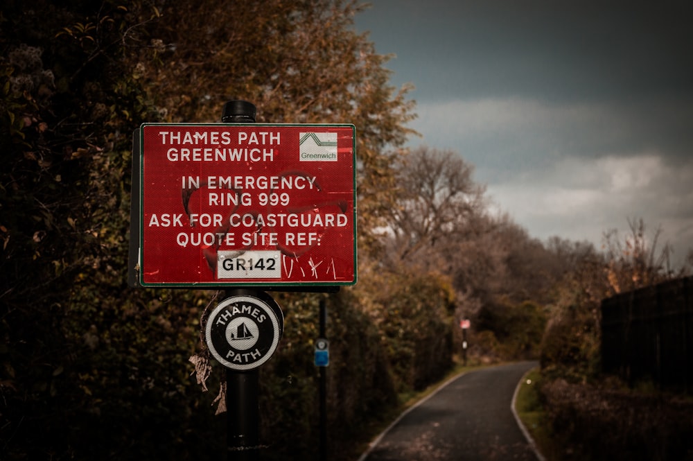 red road signage surrounded by trees during daytime