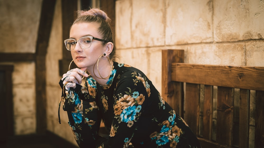 woman sitting on bench puts her elbow on her lap posing