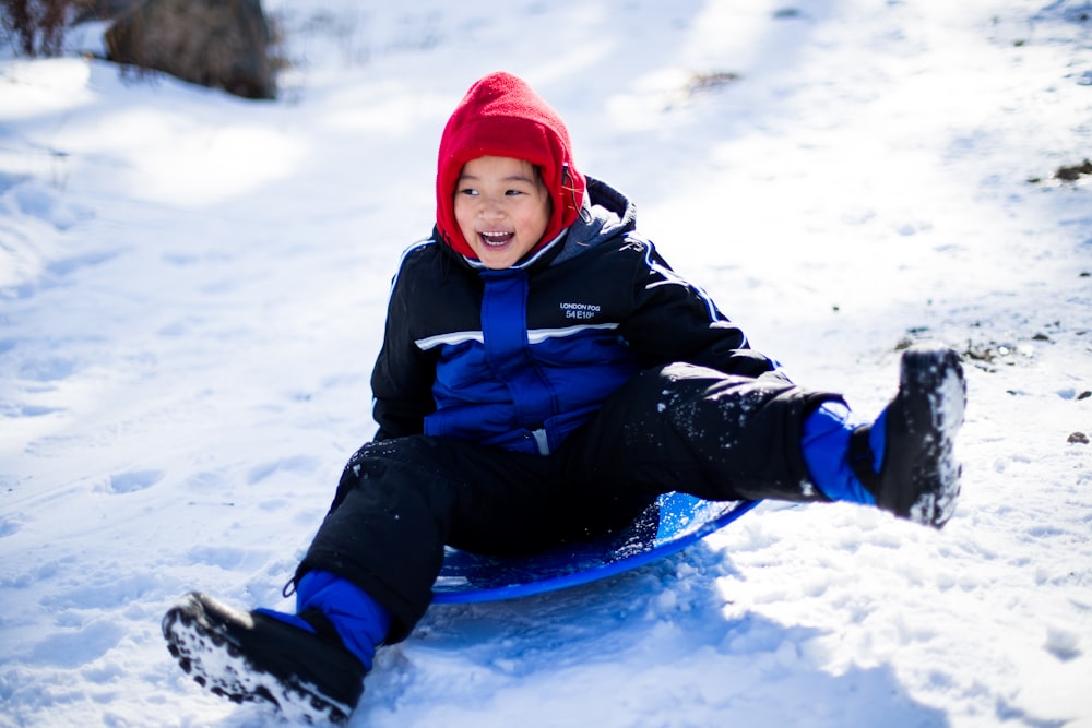 boy riding blue sled