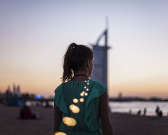 girl standing near Burj Al Arab, Dubai during golden hour