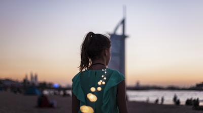 girl standing near Burj Al Arab, Dubai during golden hour