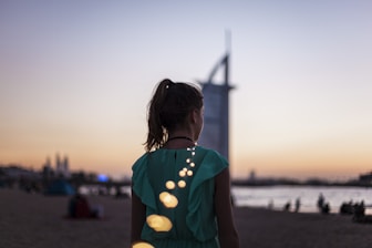 girl standing near Burj Al Arab, Dubai during golden hour