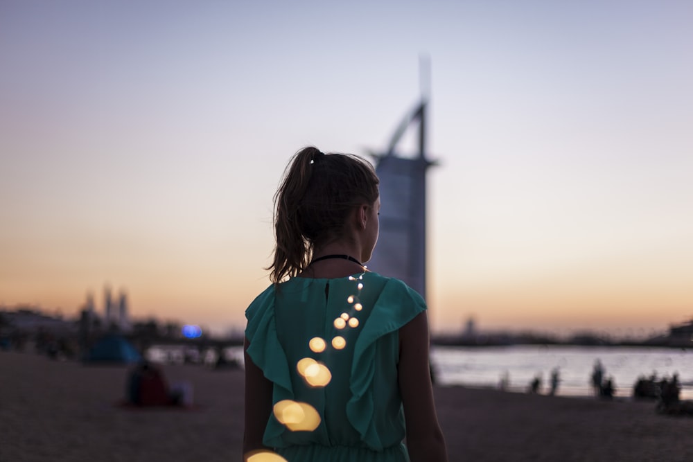 Mädchen steht in der Nähe des Burj Al Arab, Dubai während der goldenen Stunde