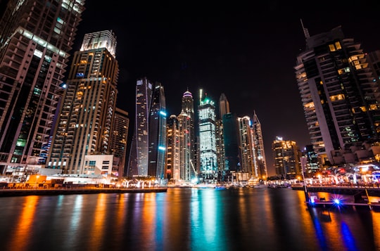 worm's eye view photography of city buildings at night in Dubai Marina Walk - Emaar United Arab Emirates