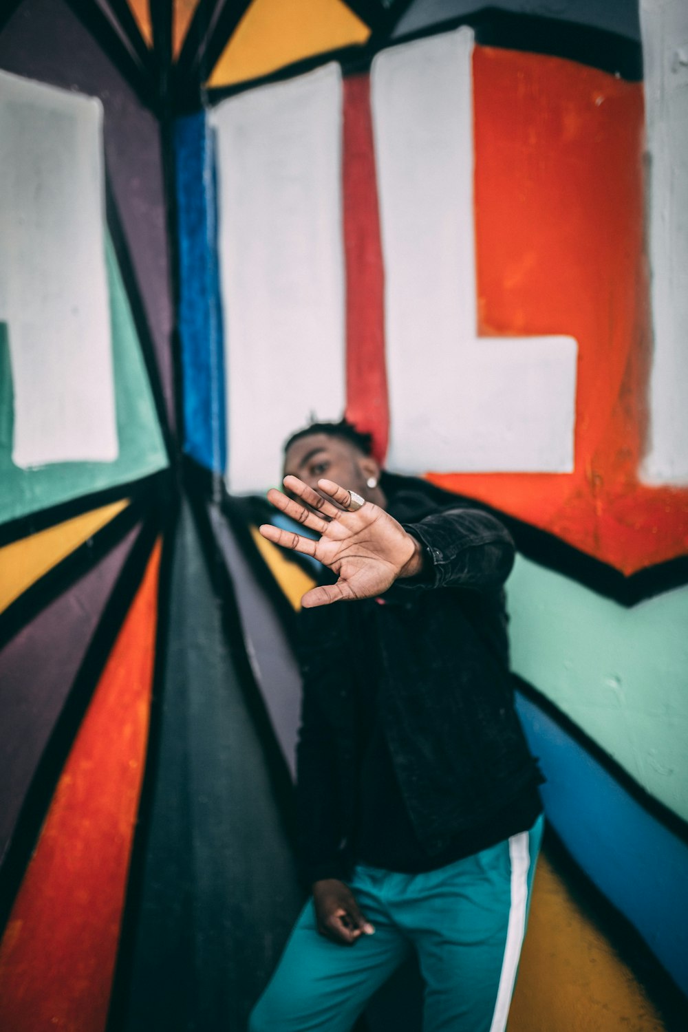 man standing near graffiti wall with arms raised up