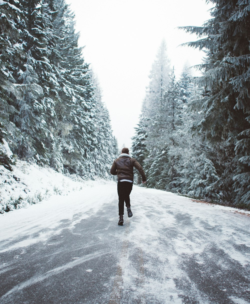 茶色のジャケットを着た男が霜の降りた道を走る