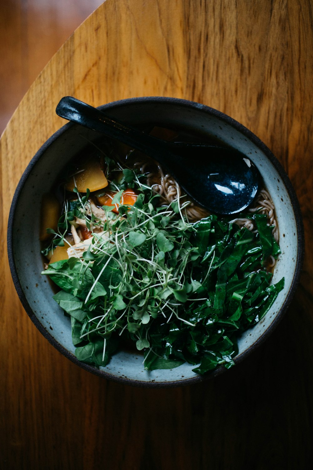 white ceramic bowl filled with noodles and leaf