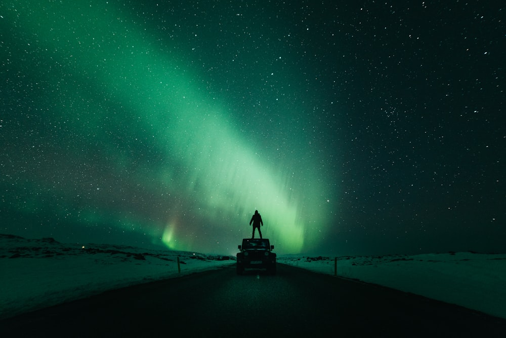 person standing in front of aurora lights