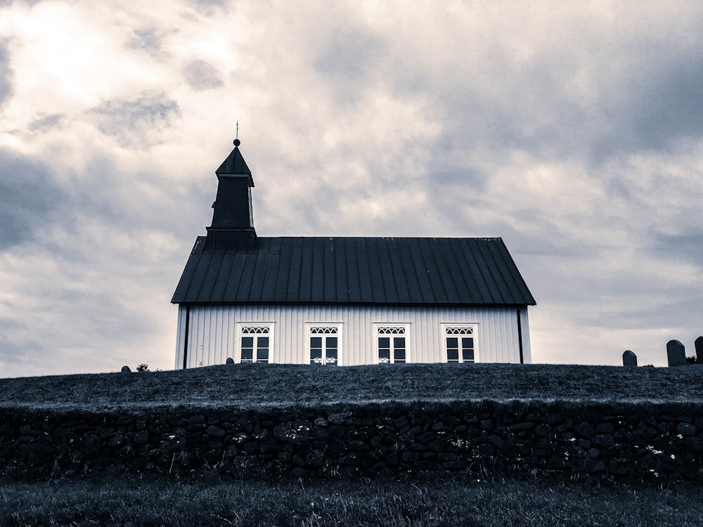 casa de hormigón blanco y negro en la montaña bajo el cielo nublado blanco