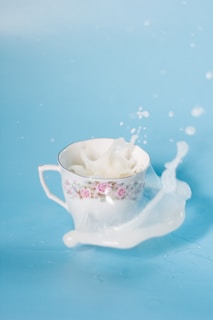 white and pink floral ceramic cup with spilled milk