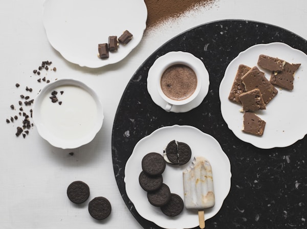 Cookies on white ceramic plate with ice cream and chocolate drink