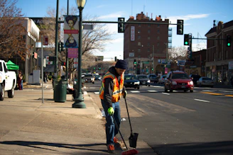 man cleaning the road near traffic light