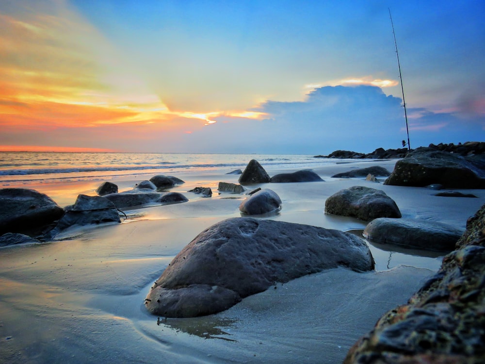 rock formation on body of water during daytime